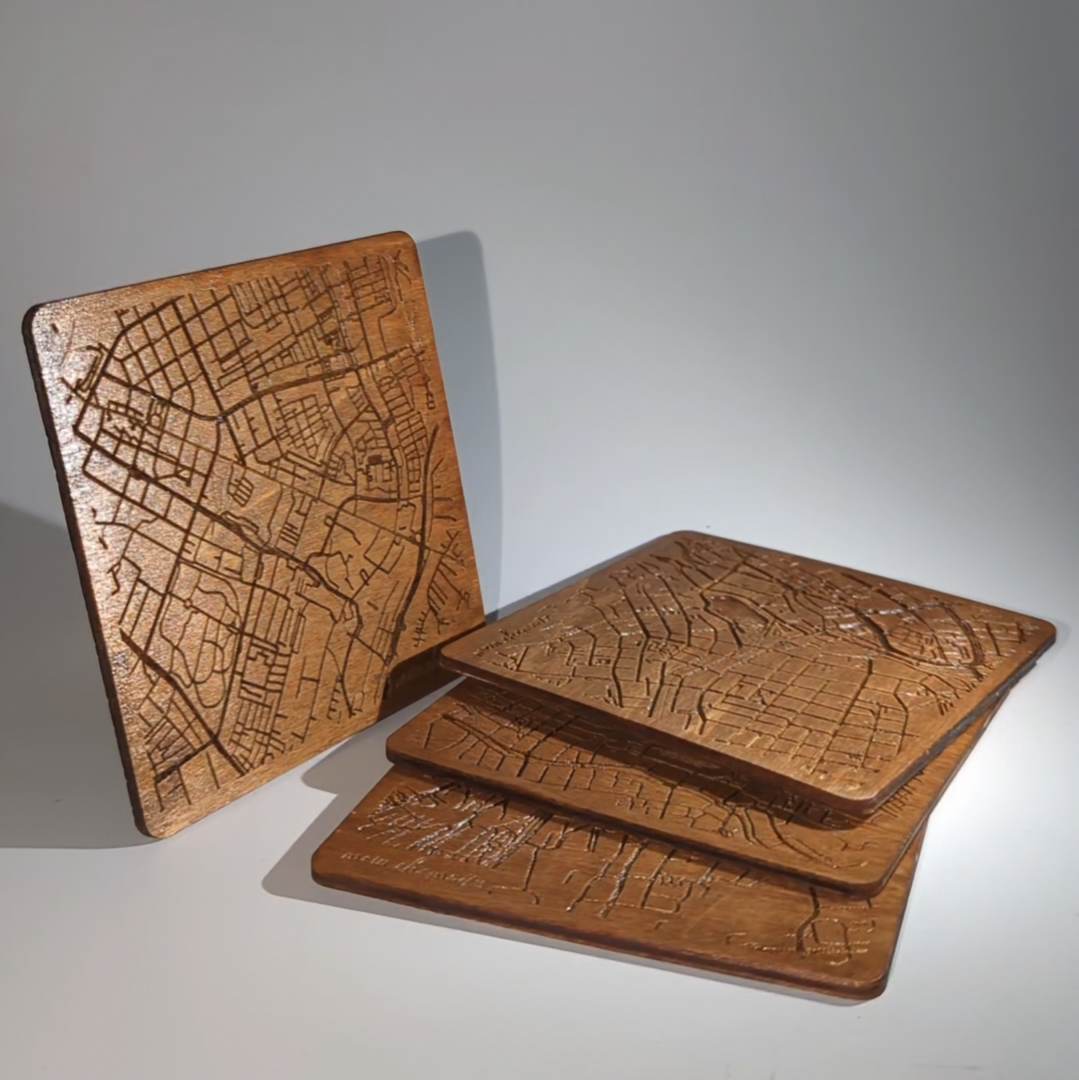 Vier Holzuntersetzer mit eingraviertem Stadtplan von Chemnitz, stapelweise präsentiert, mit einem Untersetzer aufrecht stehend im Vordergrund.