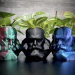 Drei Übertopfe im Design des Chemnitzer Karl-Marx-Kopfes in bunten und schwarzen Varianten – kreatives Chemnitz Souvenir