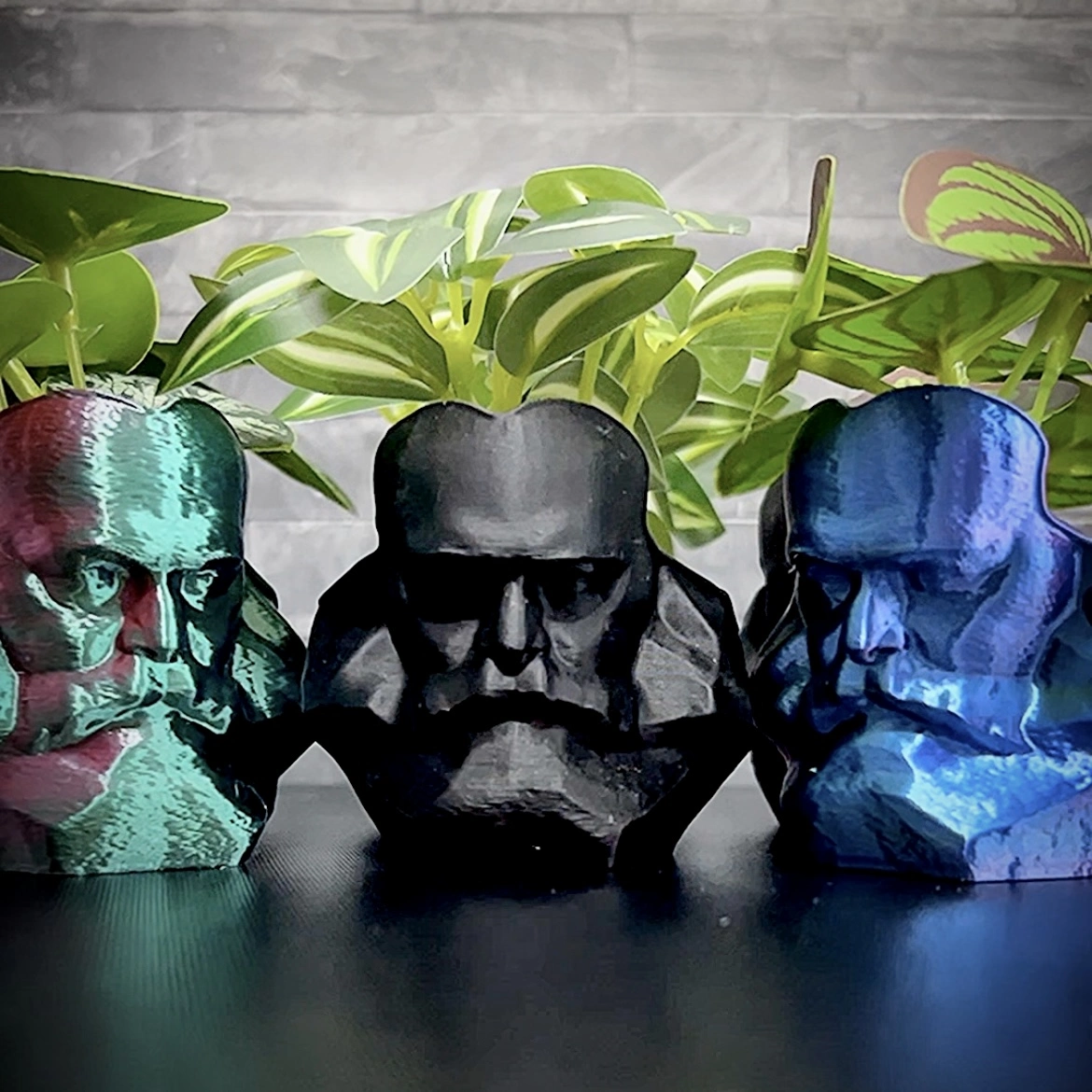 Drei Übertopfe im Design des Chemnitzer Karl-Marx-Kopfes in bunten und schwarzen Varianten – kreatives Chemnitz Souvenir